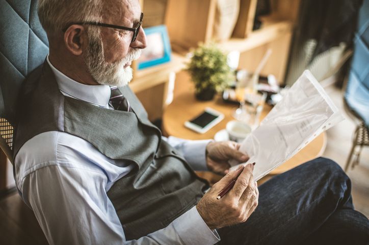 Older employee reviewing a document, sitting down