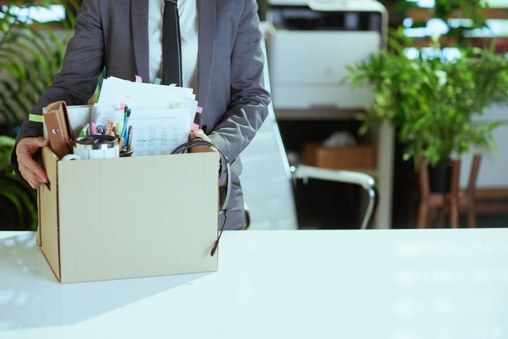 man packing a box of his office supplies after being fired