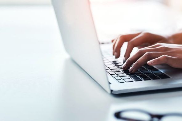Hands, laptop and a business woman typing on space in the office while working on a report or research. Computer, mockup and flare with a professional employee closeup at a desk in the workplace