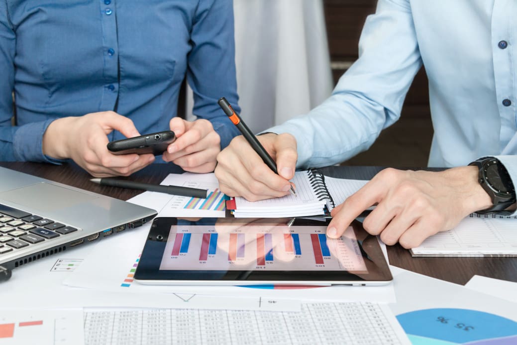 A group of business people working on a tablet at a desk.