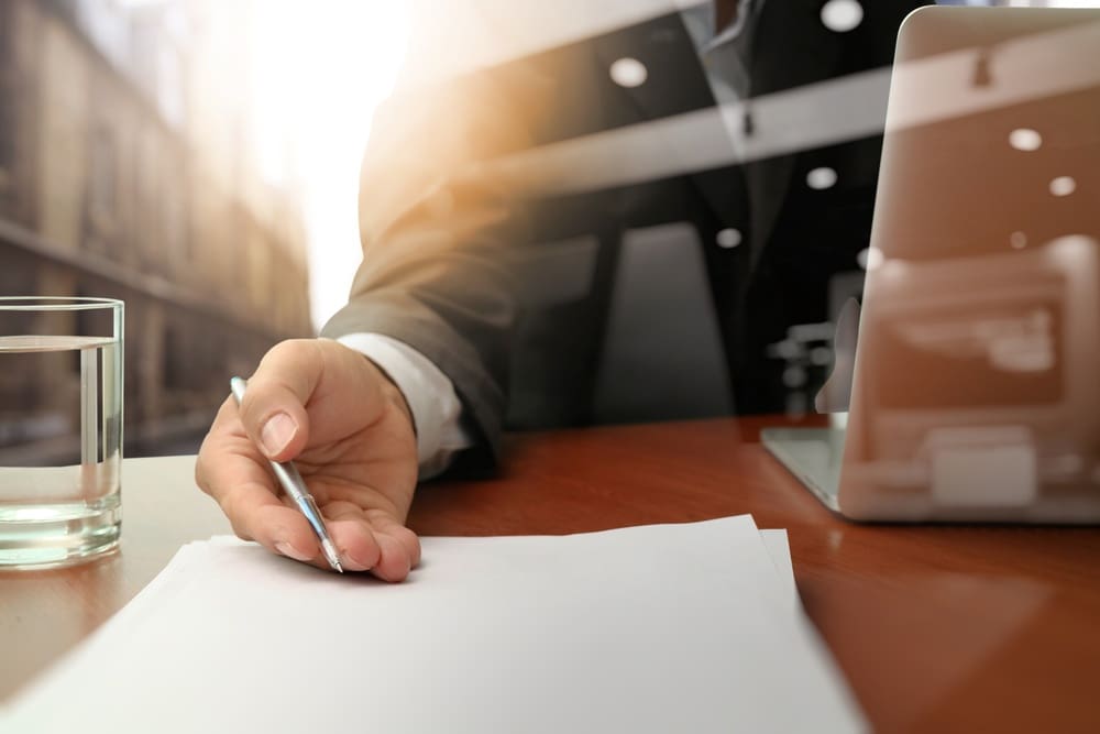 Business man handing over a contract on wooden desk