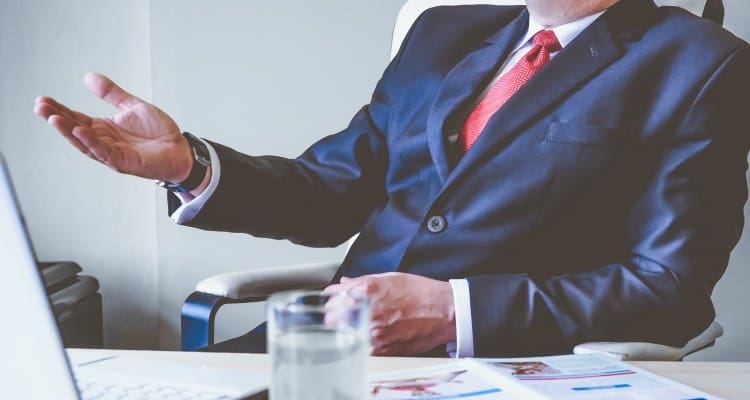 A businessman in a suit sitting at a desk.