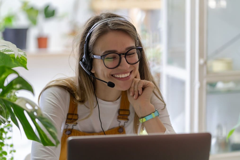 smiling-gardener-millennial-woman-wear-headphones-talk-video-calling-using-laptop-communicating-with_t20_7y8mZ6