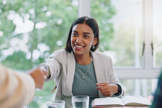 Business woman, handshake and interview thank you with success and agreement in office. Happy, hiring and female professional at company with motivation and shaking hands with job introduction