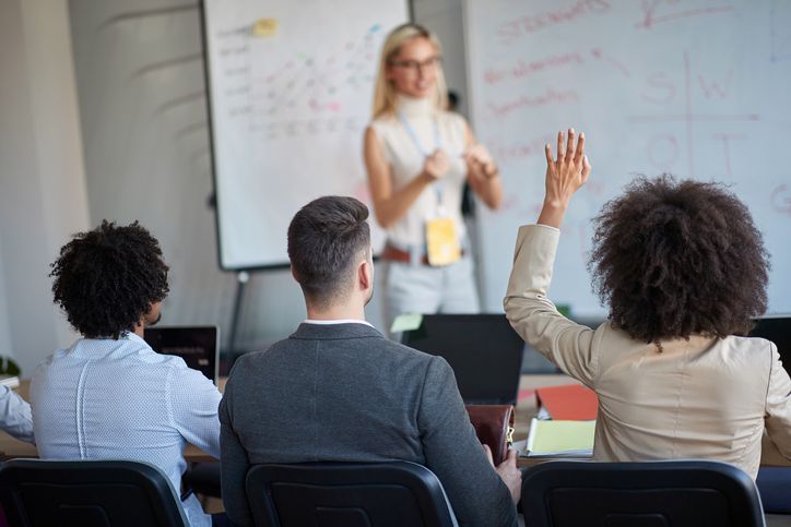 Young blonde woman teaching colleagues