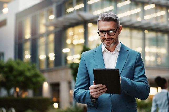 Mature, business and man with tablet outdoor for communication, research and typing email on website. Professional, male manager and digital for networking, contact and task management in urban city