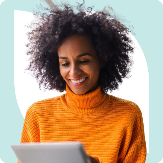 A person with curly hair wearing an orange sweater smiles while using a tablet. A light blue background is behind them.