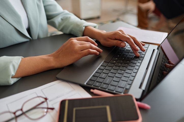 Closeup of elegant black businesswoman using laptop while working in successful career in office, copy space